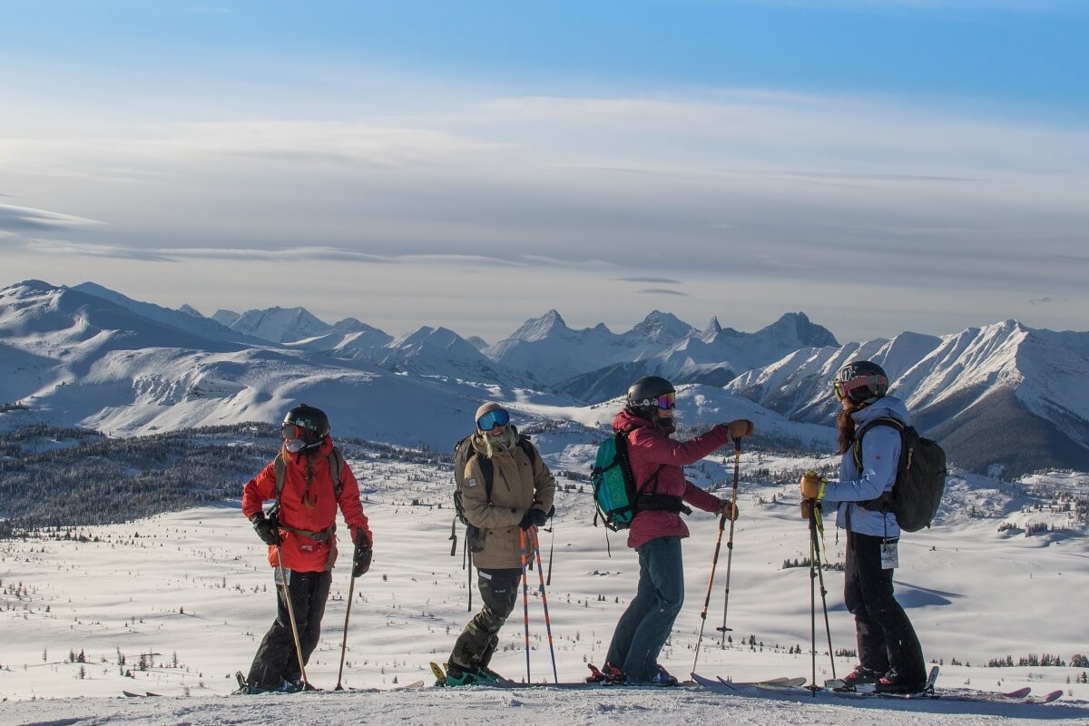 Group of skier girls with backpacks and gear on a ski trip at Lake Louise