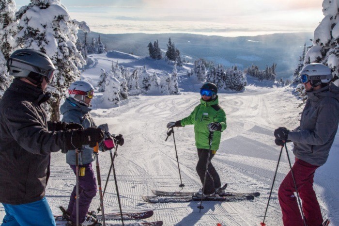 Group of four skiers on the mountain at Sun Peaks
