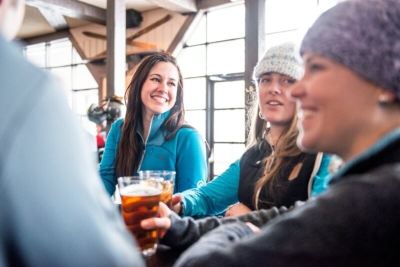 A group of women holding draft beer at a restaurant at Panorama.