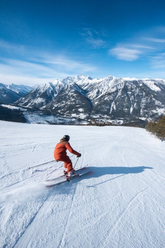 A person skiing down a snowy hill at Panorama.