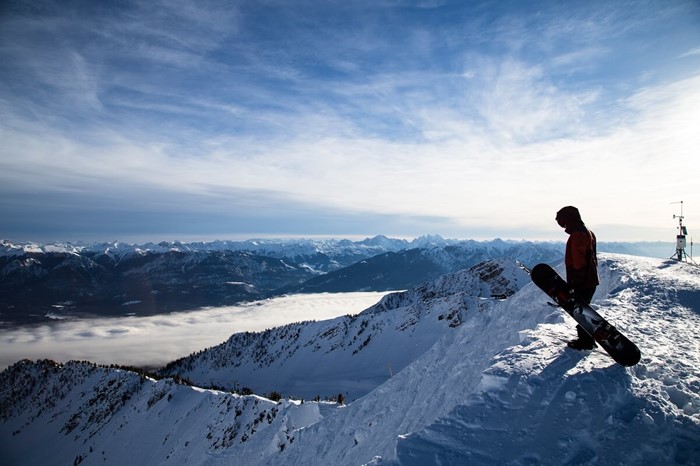 Snowboarder staring at vertical drop at Kicking Horse