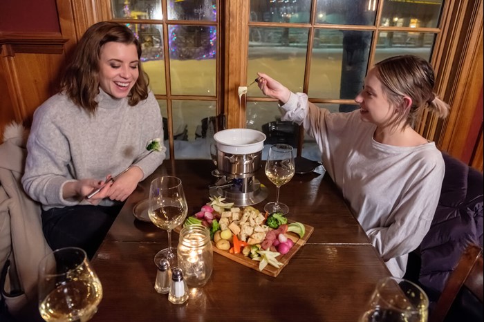 Two women enjoy wine and dinner at Big White