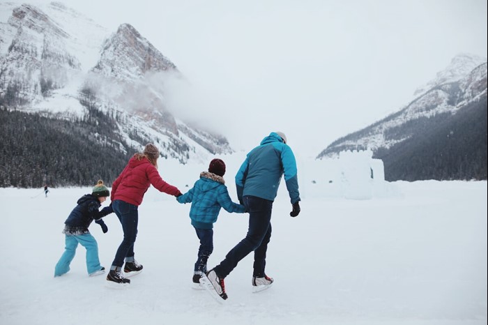 Family skating on Lake Louise during the winter