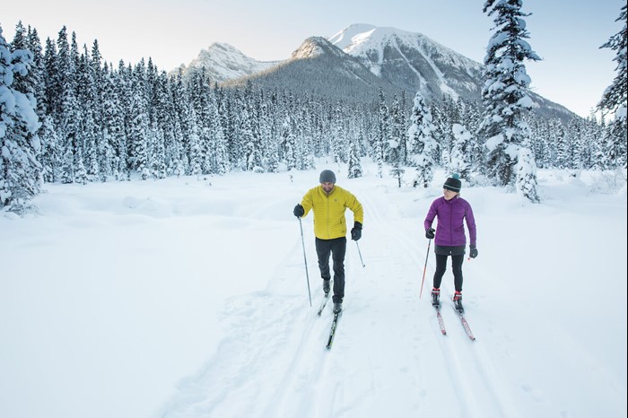 Couple cross-country skiing in the wilderness near Banff and Lake Louise