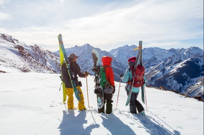 Group skiers at Aspen's Highland Bowl with backcountry skis