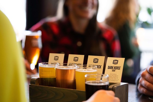 Fernie Brewing beer flight with blurred person smiling in the background