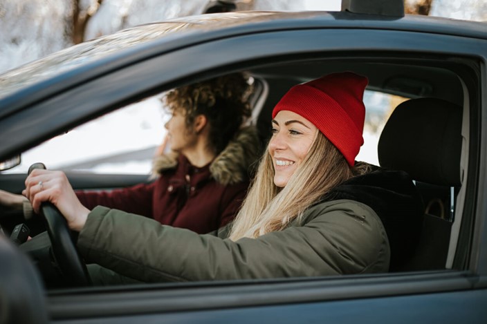Two women driving with winter gear on