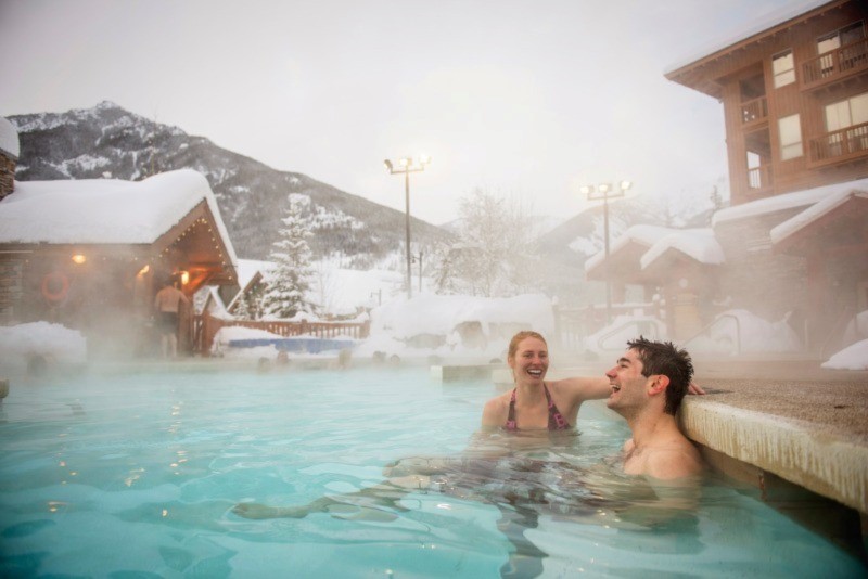 A man and woman in the hot pools at Panorama in winter.