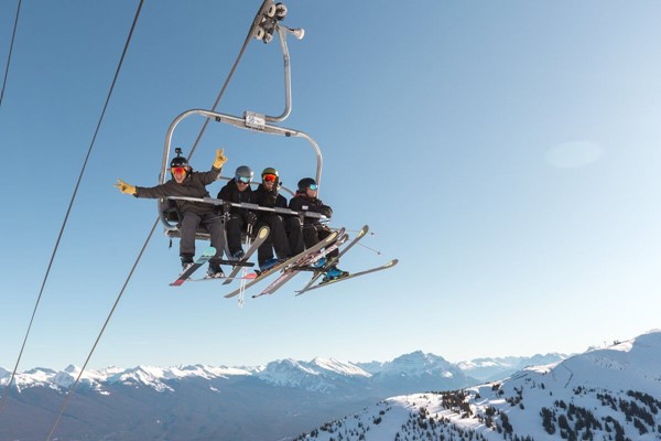 Four people in the air on a chairlift