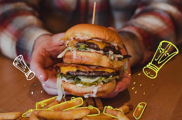 A burger with illustrated salt and pepper shakers overlayed