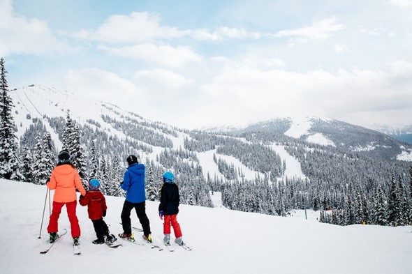 A couple and their two children at the top of Marmot Basin