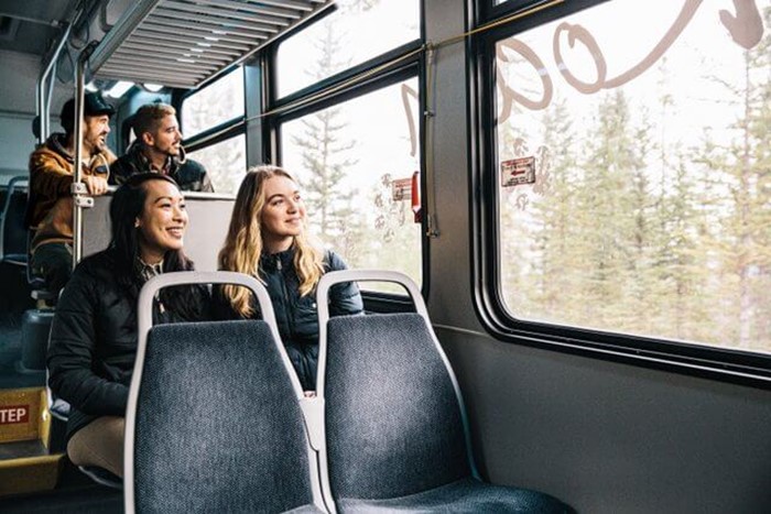 Two women on a shuttle smiling out the window