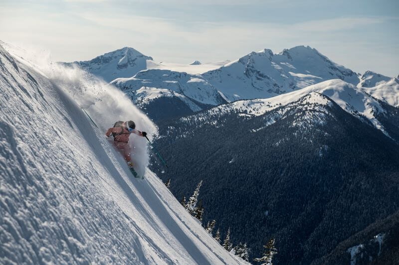 A photo of a skier going down a vertical drop on a mountain at Whistler Blackcomb.
