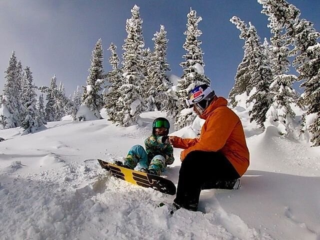 Person first bumping a child with snowboards in the snow